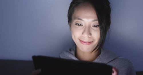Woman use of tablet computer at night