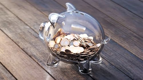 Cute glass piggy bank with huge amounts of coins. Money fast grows inside.