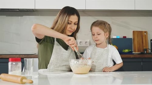 Woman and Child Baking Together in Kitchen