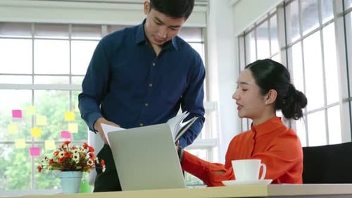 Two Business People Talk Project Strategy at Office