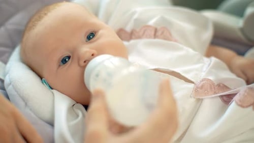 Adorable Infant being Bottle-fed with Love