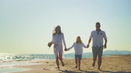 Parents with son running on sandy coast