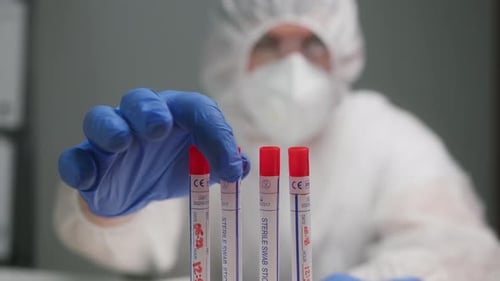 PCR Test in Laboratory Doctor Holding COVID19 Coronavirus Swab Collection Kit Wearing PPE Protective