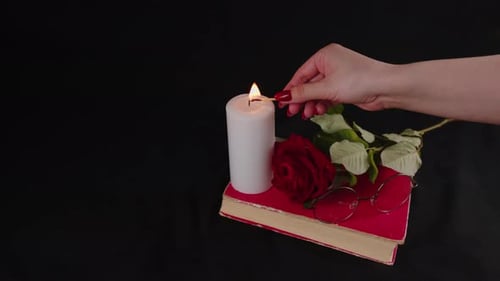Woman Lighting a Candle on Romantic Black Background