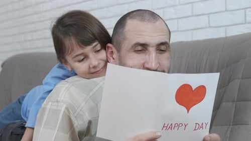Loving Child Gives Handmade Card to her Father