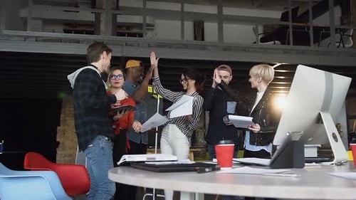 Team High-Five in Creative Workspace
