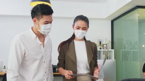 Asian young business people wear mask and discussion meeting and brainstorming, working in office.