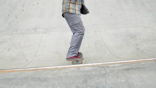 Skater Practicing in the Autumn Concrete Skate Park Making Tricks and Rides in Ramp