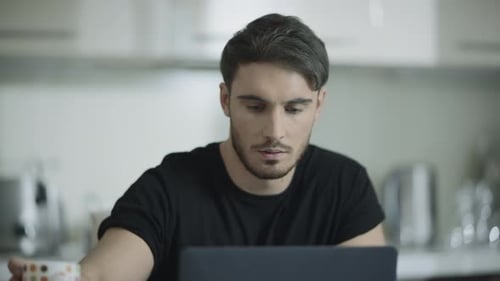 Young Man Working on Laptop at Home