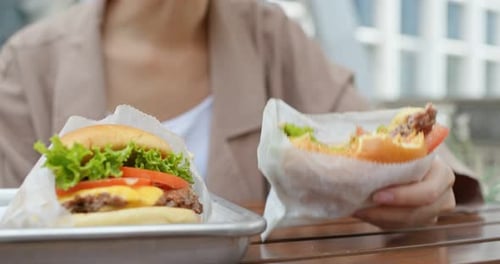 Woman eat with burger at outdoor coffee shop