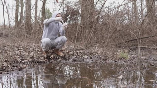 An ecologist takes a water test in a river.