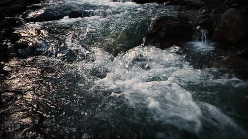 Close up of river stones with flowing water, clean water flowing in a mountain river