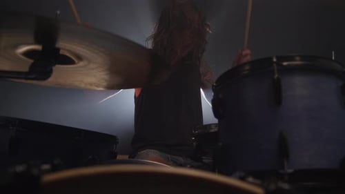 Man playing drums in heavy metal rock band, slow motion