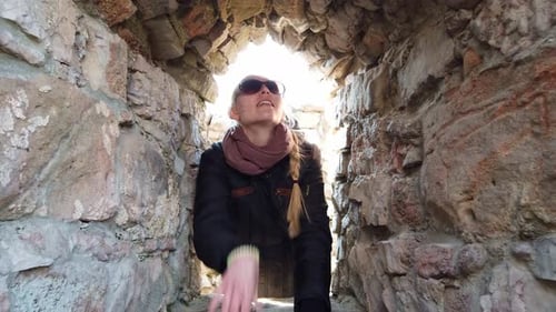 Girl Inspecting the Walls of an Old Castle in Europe.