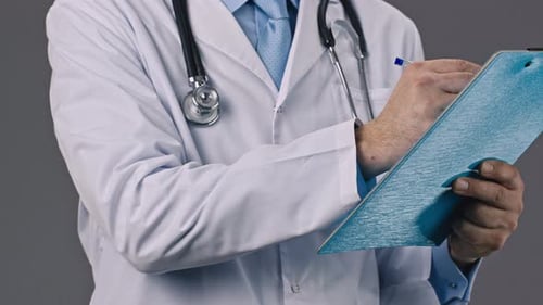 Doctor Writing on Clipboard Close Up