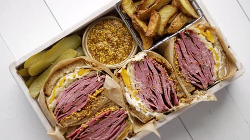 Sanduíches enormes com carne pastrami em caixa de madeira