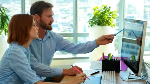 Design Team Collaborating at Modern Computer Desk