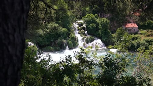 A beautiful multi-level waterfall cascades down into the turquoise river