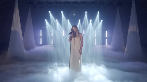 Woman Singing on Stage Surrounded by Stage Fog