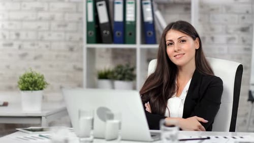 Smiling Woman at Desk in Office Setting