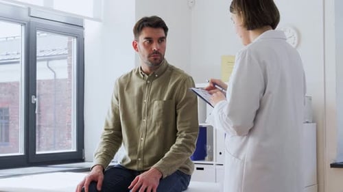 Man Patient Showing Sore Arm to Doctor at Hospital