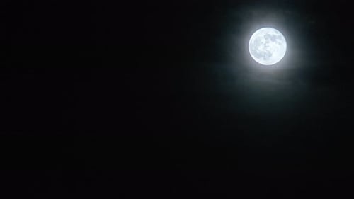 Full Moon Rising Through Clouds in the Night