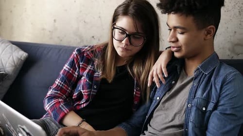 Young Couple Sharing Laptop on Couch