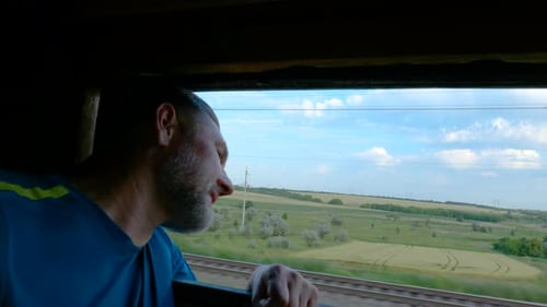 Man Travels by Train, Looking out Window