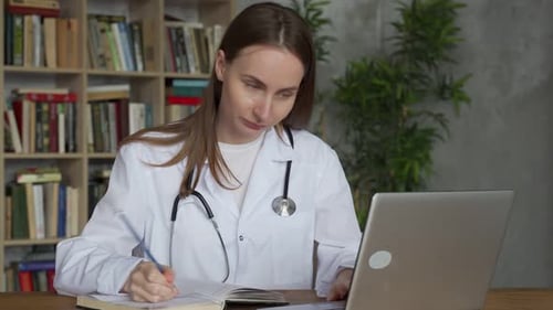 Woman Doctor Using on Her Laptop Computer in Medical Office