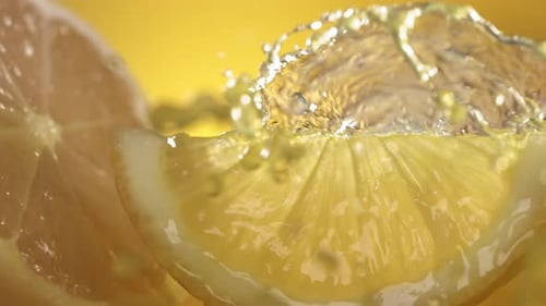 Zeitlupenaufnahme von Zitronensaft, der durch Zitronenscheiben spritzt