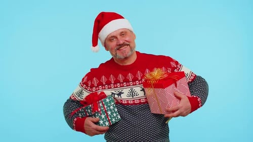 Man in Santa Hat Holding Christmas Gifts