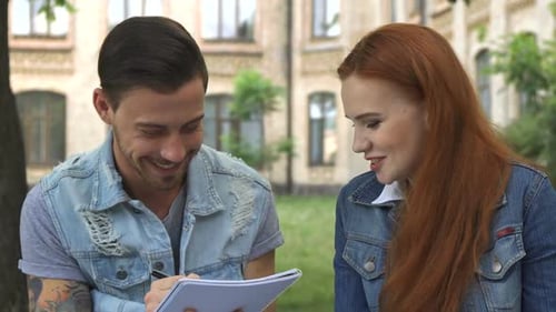 Male Student Writes Something in His Notebook