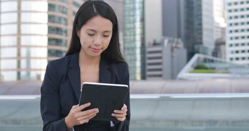 Woman Using Tablet in City Setting