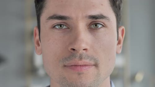 Nahaufnahme des Gesichts eines jungen Mannes, der in die Kamera blickt