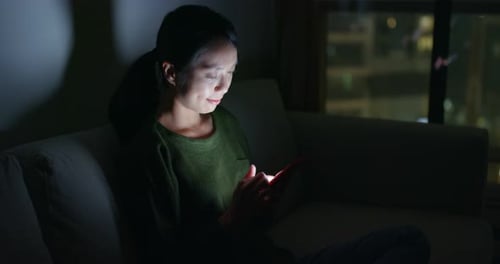 Woman Using Tablet at Night in City Apartment