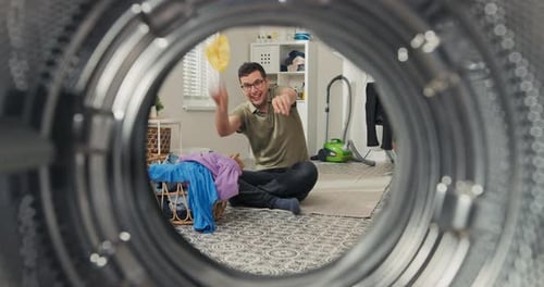 Man Sorting Laundry in Laundry Room, Viewed From Inside