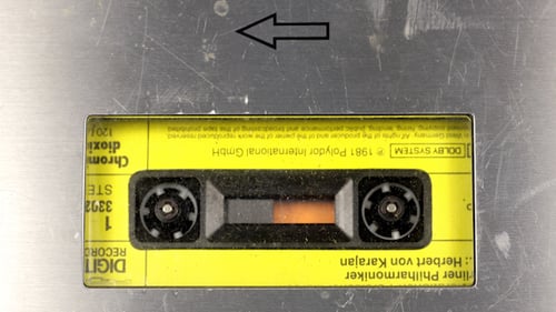Cassette Tape Rolling on Metal Surface
