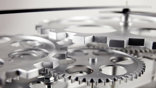 Spinning Silver Gears of Clock Mechanism in Close-Up