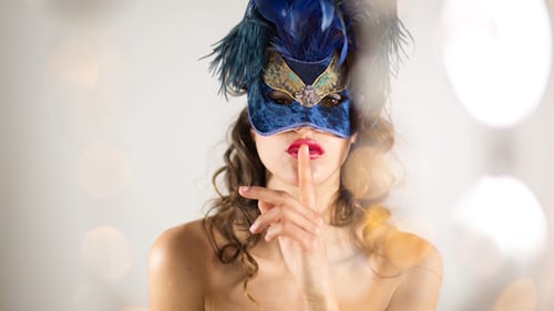 Woman Wearing Mask Holding Finger to Lips