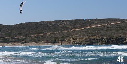Kitesurfer Rides Waves on Sunny Day at Beach