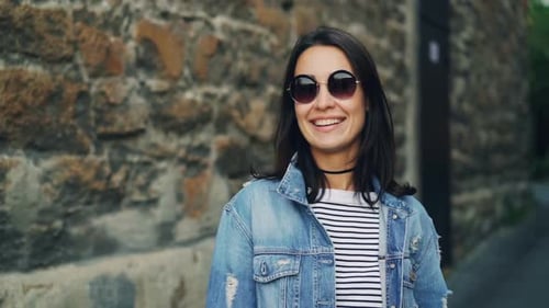 Smiling Brunette Woman in Denim Jacket on Street