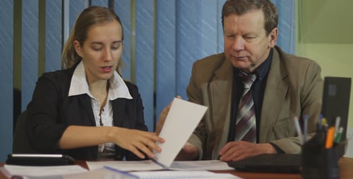 Woman and Man Discussing Business Documents