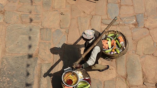 Street Food Vendor Carries Baskets of Food