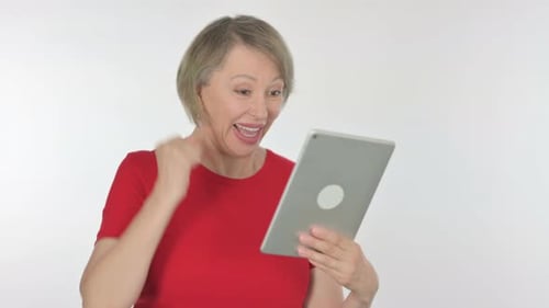 Senior Woman Celebrates Good News on Tablet