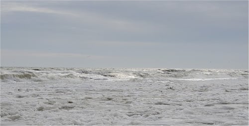 Icy Waves Crashing on Frozen Beach in Winter
