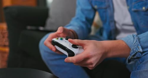 Closeup of Using Gamepad Controller Pressing Keys and Playing Competitive Action Shooter Games on TV