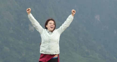 Happy Woman Celebrating Success in the Mountains