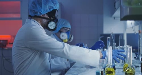 Scientists Mixing Liquids in a Lab With Masks
