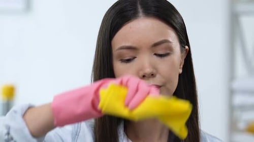 Müde Hausfrau beim Abwischen der Stirn, Erschöpfte Hausarbeit, Alltag