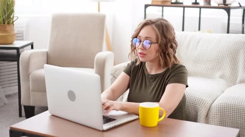 Young Woman Working on Laptop at Home